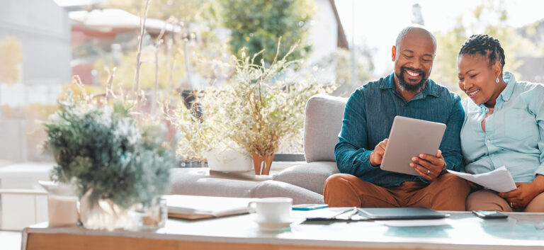 couple sitting on couch reviewing finances