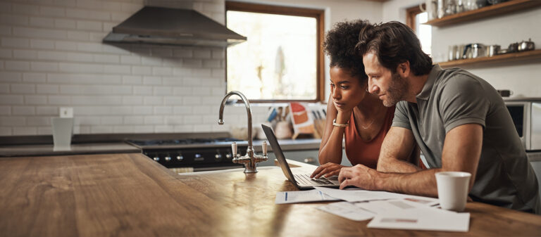 couple looking at laptop in kitchen