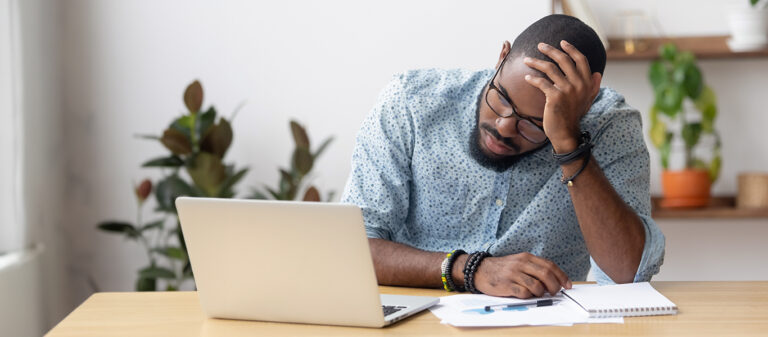 stressed man holding head in hands