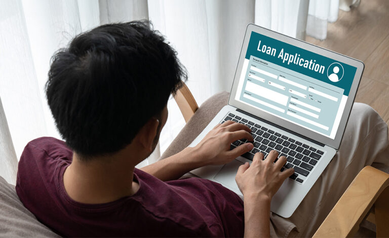 man filling out a credit application on a laptop